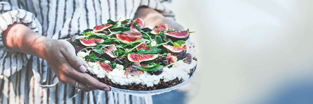 Herzhafte Schärentorte mit Feta, Feigen, Oliven und Rucola auf einem Holztisch
