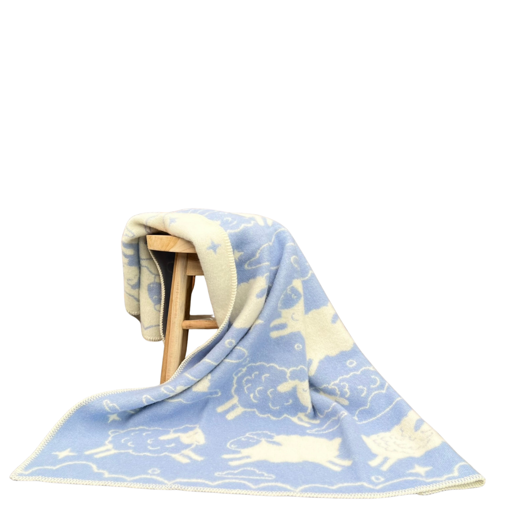 Wolldecke aus Schurwolle in hellblau weiß mit Schaf- und Wolkenmotiv für Kinderzimmer